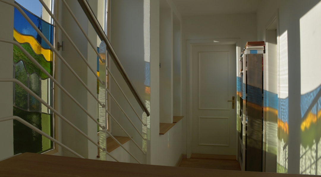 Quartychon. Vier Bleiverglasungen. Wenn die Sonne tief steht, entstehen Lichtspiele, die den nüchternen Flur in einen magischen Ort verwandeln.